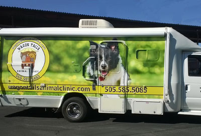 Mobile van with an image of a dog on the side and the logo for Wagon Tails Mobile Vet in Albuquerque NM